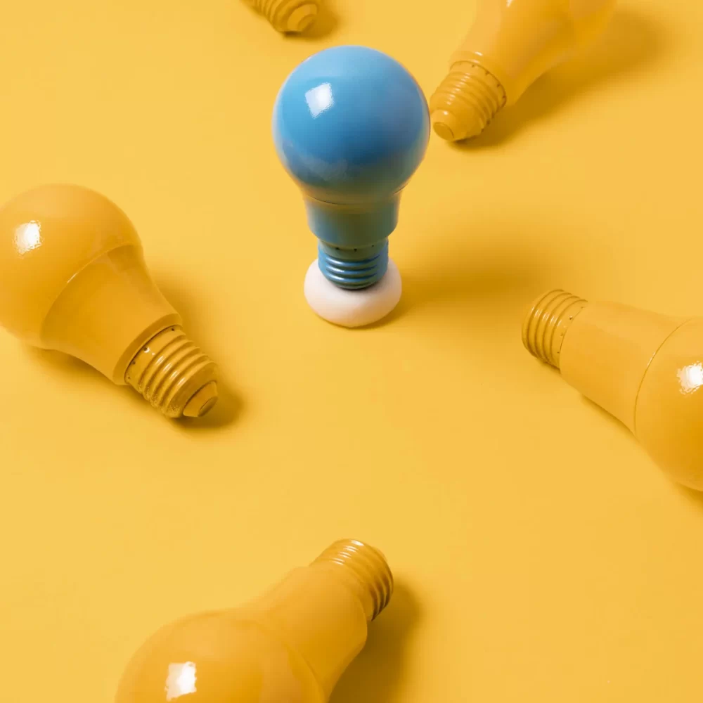 A blue bulb stands out among yellow, symbolizing how the best branding agency makes brands shine.